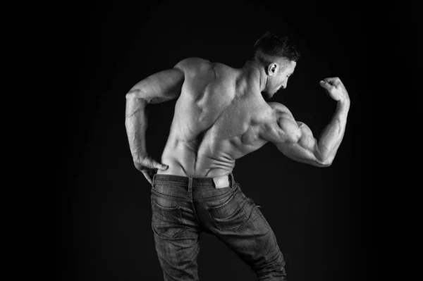 Starker Bodybuilder, der die Arme muskulös lässt, schwarzer Hintergrund. Fitter Bodybuilder mit muskulösem Körper. Professionelle Trainer zeigen Leistungen. Übungen für den Rücken. Bodybuilder perfekt in Form Rückansicht — Stockfoto