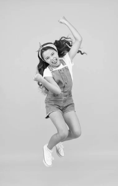 Energy inside. Feeling free. Carefree kid. Summer holidays. Jump of happiness. Small girl jump yellow background. Enjoy freedom. Childrens day concept. Spirit of freedom. Active girl feel freedom — Stock Photo, Image