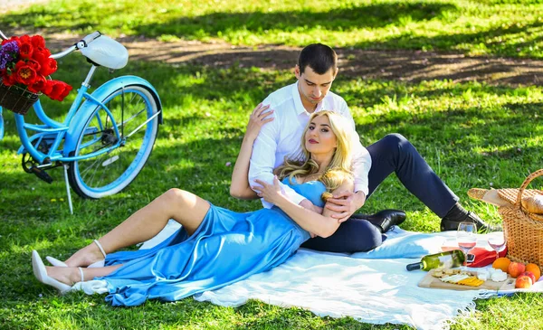 Romantische picknick. Picknick tijd. Aangekomen met de fiets. Een langdurige relatie. Een stel picknicken in het park. Bloeiende tuin. Perfect lente afspraakje. Verliefde man en vrouw. Een paar zittende dekens. Gelukkig samen. — Stockfoto