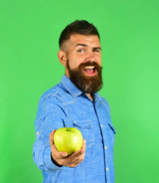 Man med skägg håller grön frukt isolerad på grön bakgrund — Stockfoto