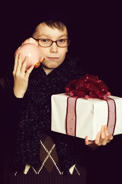 Мальчик с подарком и копилкой — стоковое фото