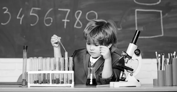 俺は仕事が好きだ。液体で試験管を研究しています。結果だ。医学的概念。天才児だ。未来のために。生物学だ。小さな男の子は化学を勉強する。レッスンで顕微鏡を使う少年は — ストック写真