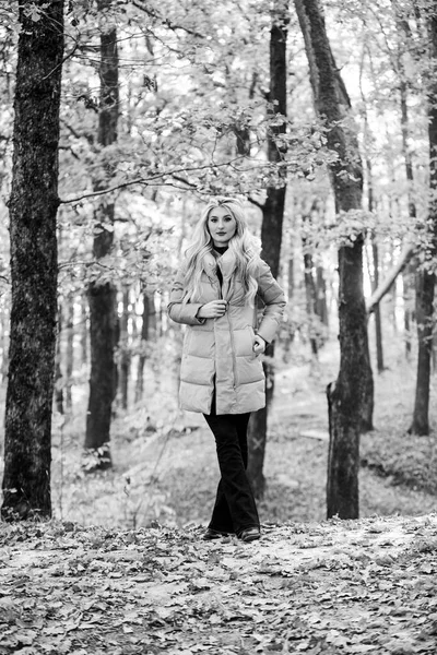 Girl fashionable blonde walk in autumn forest. Woman wear warm pink jacket. Jackets everyone should have. Best puffer coats to buy. How to rock puffer jacket like a star. Puffer fashion concept