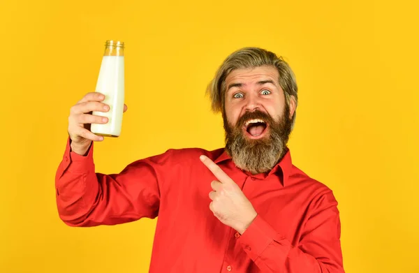 Latticini da latte per adulti e bambini. felice contadino presente vetro. uomo barbuto bere latte utile. Adoro i baffi di latte. concetto di cibo e bevande. utilità del latte. puntando il dito — Foto Stock