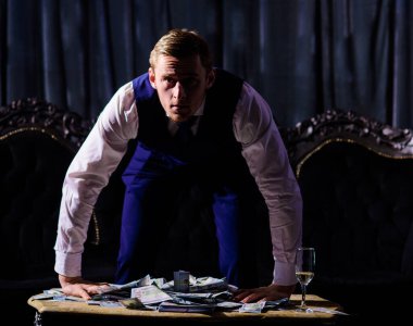 Ciddi genç adam, iş adamı, patron masaya yaslanıyor.