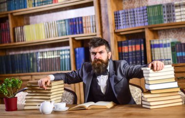Ciddi yüz konsepti. Acımasız adam kütüphanede ciddi bir suratla oturuyor..