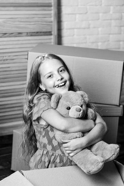 A New Wave of Living. happy child cardboard box. repair of room. new apartment. Cardboard boxes - moving to new house. happy little girl with bear toy. purchase of new habitation — Stock Photo, Image