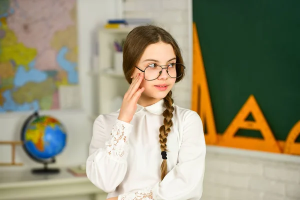 Vilken gullig skolnörd. Införande av nya arbetsenheter. Grabben bär glasögon. Tillbaka till skolkonceptet. Läsa bok som hobby. Utbildning och barnlitteratur. Romantisk skolflicka i klassrummet — Stockfoto