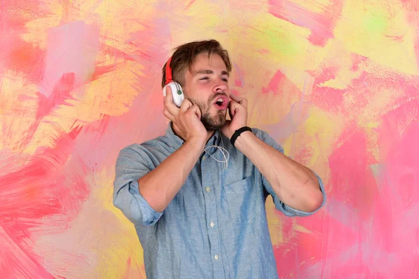 Americano guapo barbudo con auriculares. Alegre adolescente dj escuchar canciones a través de auriculares . — Foto de Stock