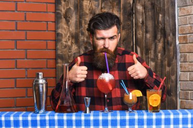 Hipster içkiyi sever ve onaylar. Sakallı barmen.