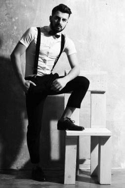 Stüdyo duvarında ciddi bir yüzü olan sakallı bir adam.