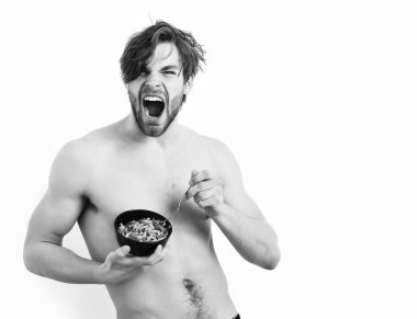 Kafkas seksi genç maço elinde makarna ile siyah kase tutuyor.