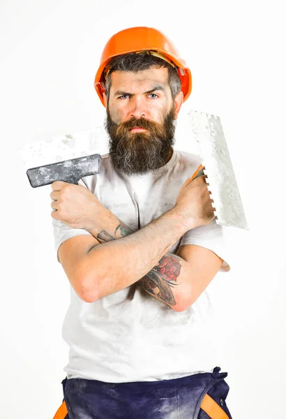Hombre con cara seria sostiene cuchillo masilla y herramienta de enlucido . — Foto de Stock