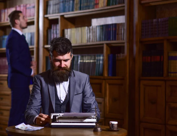 Giovane che scrive su vecchia macchina da scrivere con biblioteca o libreria — Foto Stock