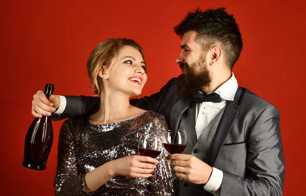 Vrouw in sprankelende jurk en man met fles wijn — Stockfoto