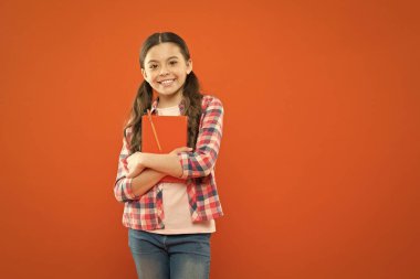 Çocuklar için çevrimiçi kurslar. Kız çocuk kucaklaması ders kitabı turuncu arka plan. Ders çalışmak eğlencelidir. Ekstra okul kursu. Okul konsepti. Öğrenci ders kitabı taşıyor. Gençler için dil kursları. Eğitim kursları