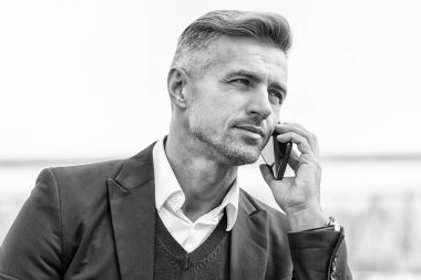 İş iletişimi. Yeni teknoloji. Çevrimiçi iletişim. Modern iletişim. İş adamı cep telefonunu tutar. Dışarıda cep telefonu olan yakışıklı bir adam. Profesyonel kullanım için telefon. Taşınabilir yaşam biçimi