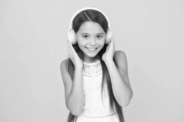 Musik hören. kleines Mädchen mit Kopfhörern. Mit der Musik ist sie zufrieden. Konzept moderner Technologien. Ich bin so aufgeregt. glückliches Mädchen mit Kopfhörern. Lasst uns spielen. E-Learning-Klasse für Schulen — Stockfoto