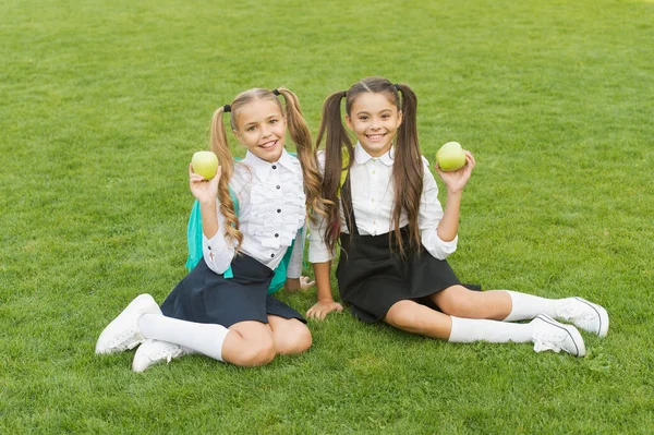 Przerwa na posiłek może być zabawna. Szczęśliwe dzieciaki trzymają jabłka na zielonej trawie. Małe dziewczynki cieszą się przerwą w szkole na świeżym powietrzu. Zdrowe jedzenie i przekąski. Naturalna przekąska. Jedzenie i odżywianie. Przerwa obiadowa — Zdjęcie stockowe