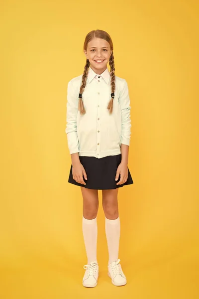 Curso escolar. menina feliz em uniforme escolar. de volta à escola. moda infantil. mercado escolar. conceito de educação. Dia do conhecimento. felicidade infantil. menina inteligente no fundo amarelo — Fotografia de Stock