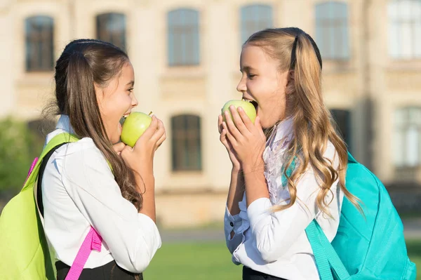 Jabłka dobre na zęby. Szczęśliwe dziewczyny jedzą jabłka na zewnątrz. Zielone jabłka na szkolną przekąskę. Zdrowe jedzenie. Źródło witamin. Organiczne i naturalne jedzenie. Jabłka są pożywne. Świadczenia zdrowotne — Zdjęcie stockowe