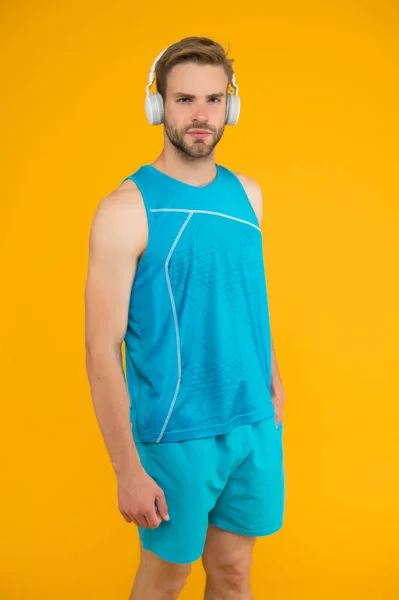 Le sport est meilleur avec la musique. Entraînement confortable avec la liste des pistes préférées. Casque sans fil pour le sport. Concept de casque moderne. Homme beau sportif non rasé écoutant musique casque gadget — Photo