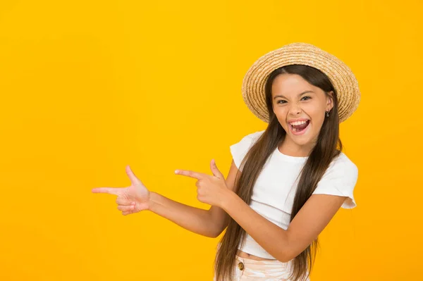 Ich mag den Sommer. Glückliches Kind zeigt auf gelben Hintergrund. Kleines Mädchen mit spitzer Geste. Zeigefinger zeigen. Hinweis auf Werbung. Sommerferien. Urlaub machen, Raum kopieren — Stockfoto