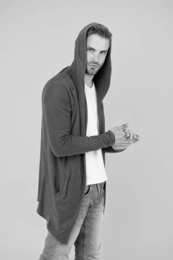 Sıradan, gayretsiz bir tarz. Şık bir adam şık bir kapüşonlu giyer. Yakışıklı adam sarı arka plan. Moda ve tarz. Günlük kıyafet ya da spor giysi. Koruyucu dış giysi. Rahat ve sıcak. Günlük biçim