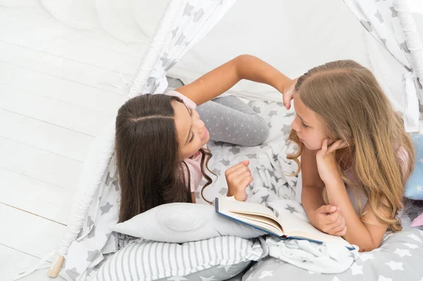 Girls sisters cute pajamas relax and read book. Lockdown ideas for kids. Keep studying at home. Favorite fairy tale. Book about love. Girls children lay bed read book. Pleasant time in cozy bedroom — Stock Photo, Image
