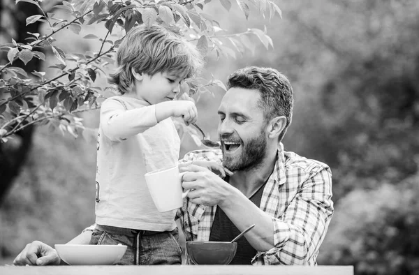 Baba oğul dışarıda yemek yiyorlar. Birlikte vakit geçirmeyi seviyoruz. Vejetaryen diyeti. Sağlıklı yemek ve diyet. Süt ürünleri. Babalar günün kutlu olsun. Babasıyla küçük çocuk mısır gevreği yiyor. Aile yemeği zamanı.