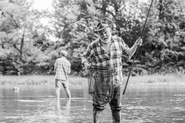 fishing time. family bonding. summer weekend. two fishermen with fishing rods, selective focus. retired mature man fisher. hobby and sport activity. father and son fishing. male friendship clipart