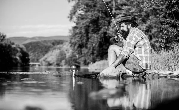 Mann beim Fischfang. Männer am Flussufer genießen die friedliche idyllische Landschaft beim Angeln. Kerl Fliegenfischen. erfolgreiches Fliegenfischen. Hobby für Seele. vereint mit der Natur. Fischer Fischereitechnik verwenden Rute — Stockfoto