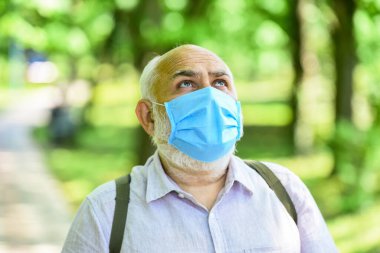 Maske virüsten korunuyor. Maske tak. Karantina genişletildi. Kilitleme kısıtlamalarını gevşetiyorum. Salgın hastalık konsepti. Enfeksiyonun yayılma riskini sınırla. Kıdemli adam maskesi. Yaşlı insanlar yüksek riskli covid-19