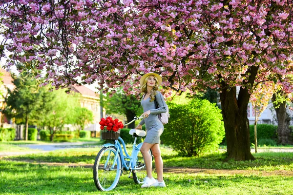 Wycieczka do ogrodu. Sportowa kobieta jeździ na rowerze retro. Podróż rowerem. Koncepcja weekendowa. Wiosenne wakacje. Jazda na rowerze. Dziewczyna i sakura kwitną. Wycieczki rowerowe. Odpocznij i podróżuj. Razem z naturą — Zdjęcie stockowe