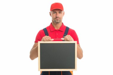 Vasıflı tamirci hizmetlerini sunuyor. Şapkalı erkek işçi karatahtayı tutuyor. Kopya alanı için pano. İnşaat hizmeti reklamı. En iyi teklif. taşıma veya yeniden yerleştirme yükleyicisi