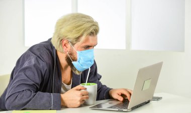 Coronavirus karantinası. Online eğitim ve dersler. İş yerinde solunum riskleri yaygındır. Ofiste mesafelere göre çalışan bir adam. Kişisel temas olmadan. iş yapma çevrimiçi