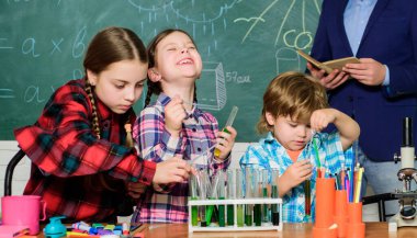 Laboratuvar ya da kimya dolabında deney yapmak. Okula dönüyorum. Kimya laboratuvarı. Mutlu çocuk öğretmenim. Laboratuvar önlüklü çocuklar laboratuarda kimya öğreniyor. Tedaviye odaklanmış.