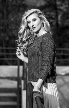 Sonsuza kadar burada kalırdım. Uzun sarı saçlı kız şehir yürüyüşü. Sonbahar kadını kıvırcık saçlı. Kadın güzeli. Etek ve süveter giyen kız. Pileli trend. Haidresser ve makyaj. Sonbahar moda sezonu