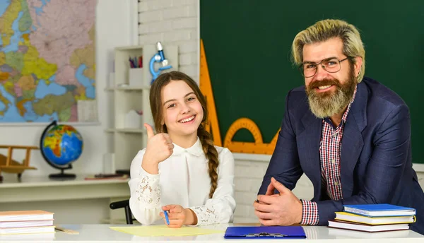 Lerarendagconcept. Adviserende student. Thuisschoolproject. Schoolmeisje studeert met persoonlijke leraar. Klein meisje en man tegen schoolbord. Kennisdag. Kind met leraar in de klas — Stockfoto