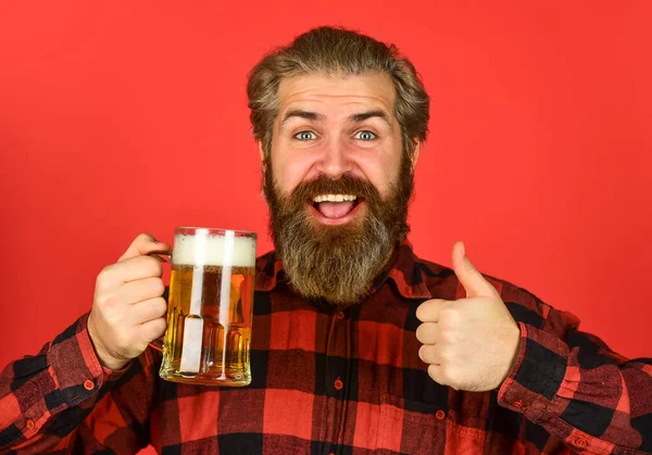 Refresca tu espíritu. Un hipster moderno emborrachándose. Bebida de bienvenida. Un hombre barbudo brutal bebe cerveza. Cervecería. Bar cantinero. Un hombre tiene una taza de cerveza. Hipster en el mostrador del bar. Divirtiéndose. Bebida alcohólica — Foto de Stock