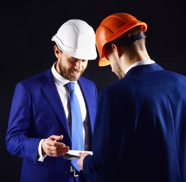 Gülümseyen yüzlü bina müfettişi mimarla konuşuyor..