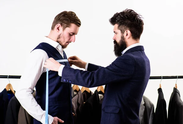 Businessman, client stand near hanger with suits — Stock Photo, Image