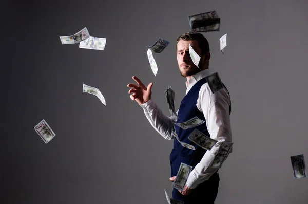 Άντρας με επίσημη ενδυμασία, επιχειρηματίας ρίχνει χρήματα σε γκρι φόντο. — Φωτογραφία Αρχείου