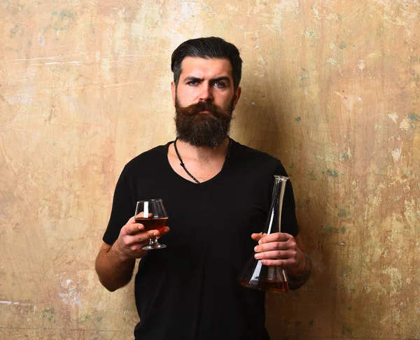 Mężczyzna z brodą i wąsami trzyma napoje alkoholowe — Zdjęcie stockowe