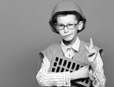 Kırmızı stüdyo arka planında genç, şirin inşaatçı çocuk, kopyalama alanı