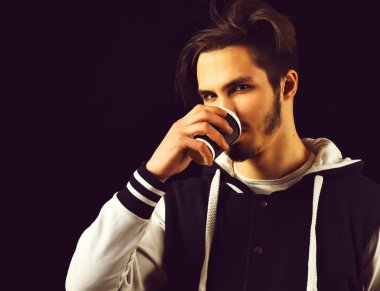 Siyah stüdyo geçmişinde beyzbol ceketli sakallı adam.