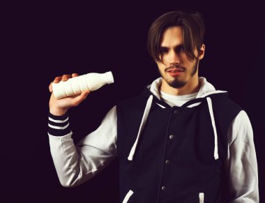 Siyah stüdyo geçmişinde beyzbol ceketli sakallı adam.