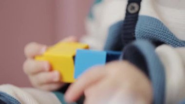 Renkli plastik tuğlalarla oynayan bir yaşında bir oğlan çocuğu. Renkli lego küpleriyle oynayan mutlu küçük bebek. Çocuğun gelişimi.