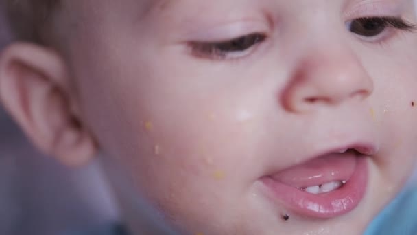 Schattig jongetje met een brede glimlach laat zijn tandeloze zitten op een stoel zien. Portret van een eenjarig jongetje — Stockvideo