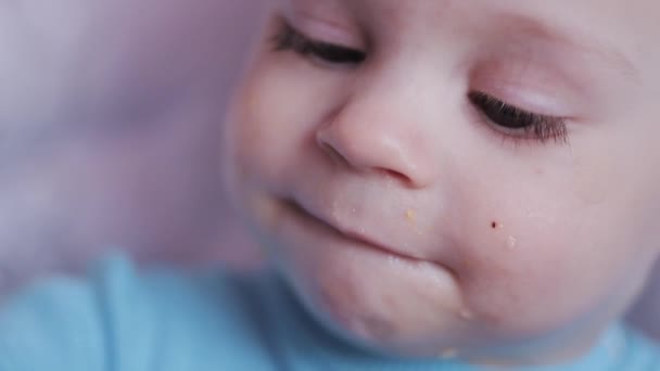 Schattig gelukkig baby kind jongen eten van fruit op kinderstoel. — Stockvideo